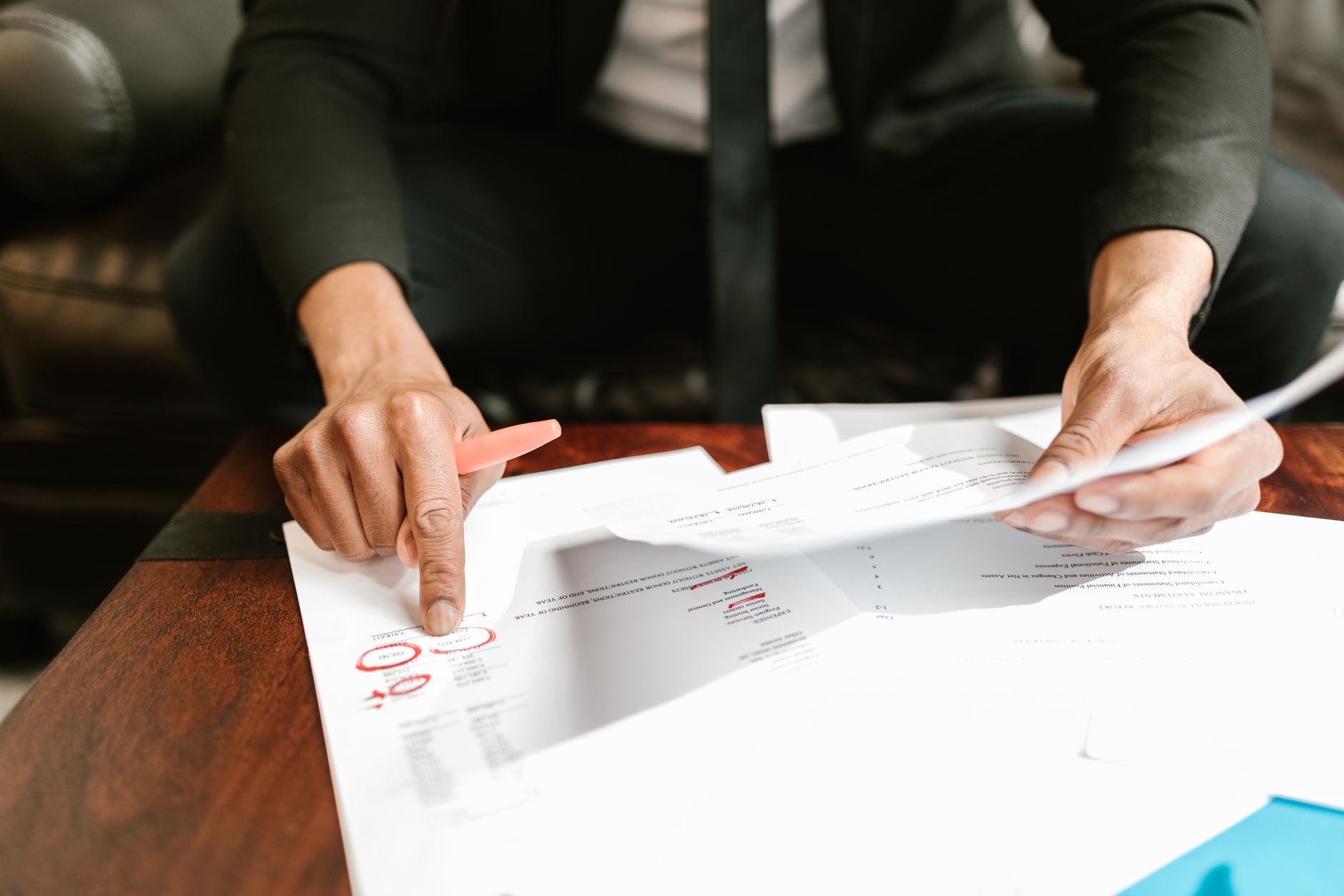 An accountant marking up a set of financial statements in red pen